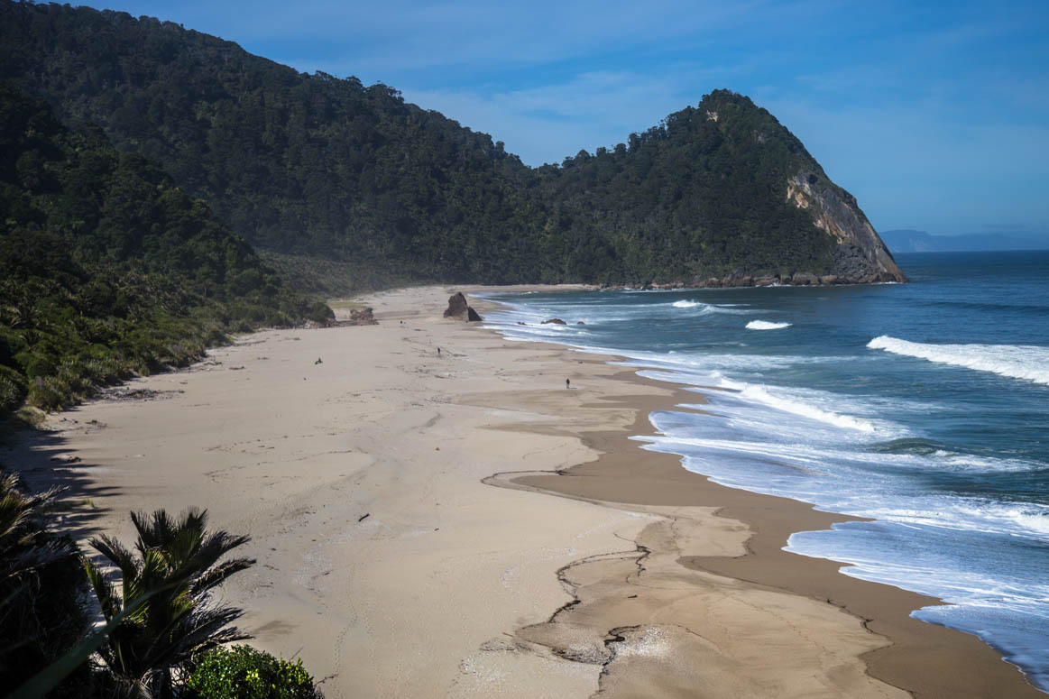 den Strand entlang wandern